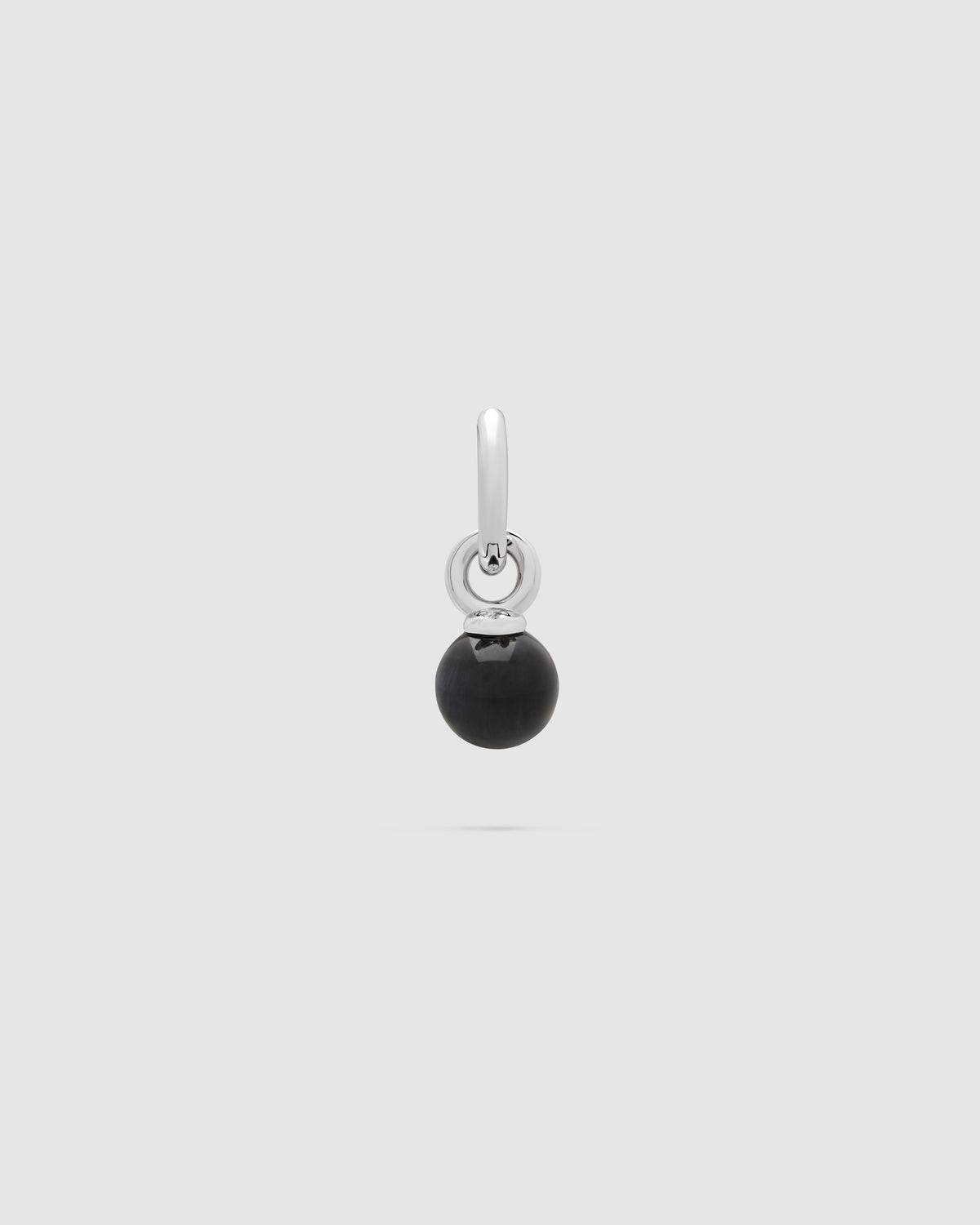 A silver-toned drop earring featuring a polished black spherical bead pendant, shown against a solid light gray background.