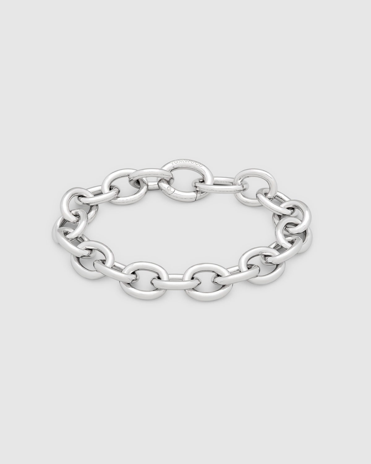A polished silver chain link bracelet with a flat, wide oval link design, displayed on a light gray background.