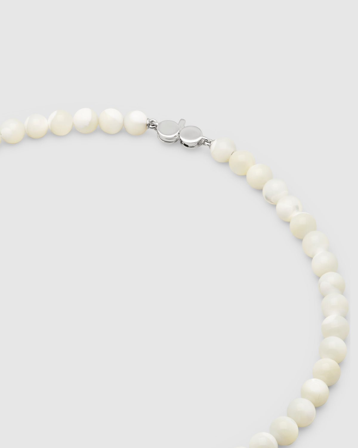 Tom Wood Cove Necklace White MOP - A close-up of a pearl necklace with round, off-white pearls and a silver clasp.