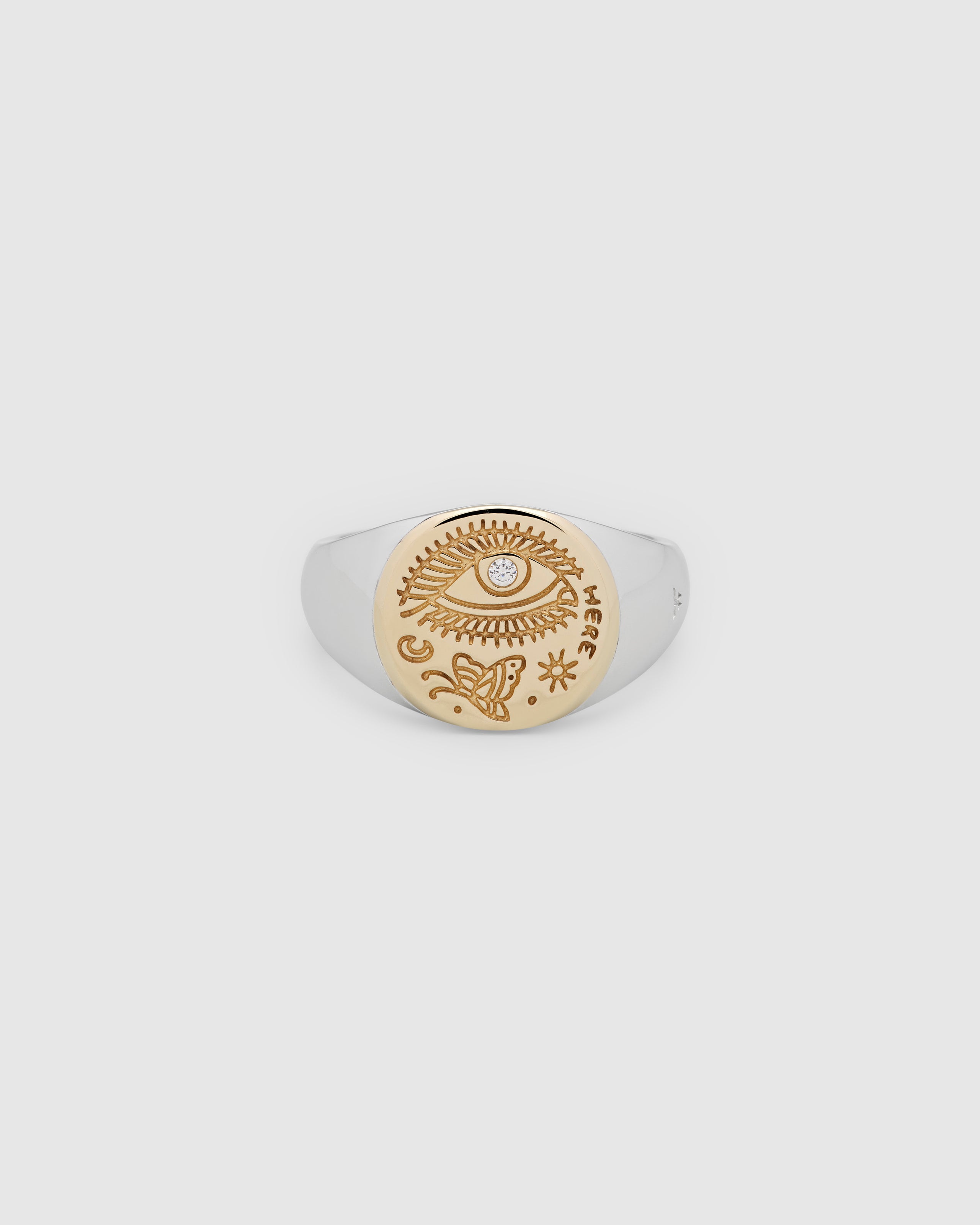 A small, round gold and 925 sterling silver signet ring for men and women, featuring an engraved butterfly motif and a hand-set, lab-grown diamond on the surface.