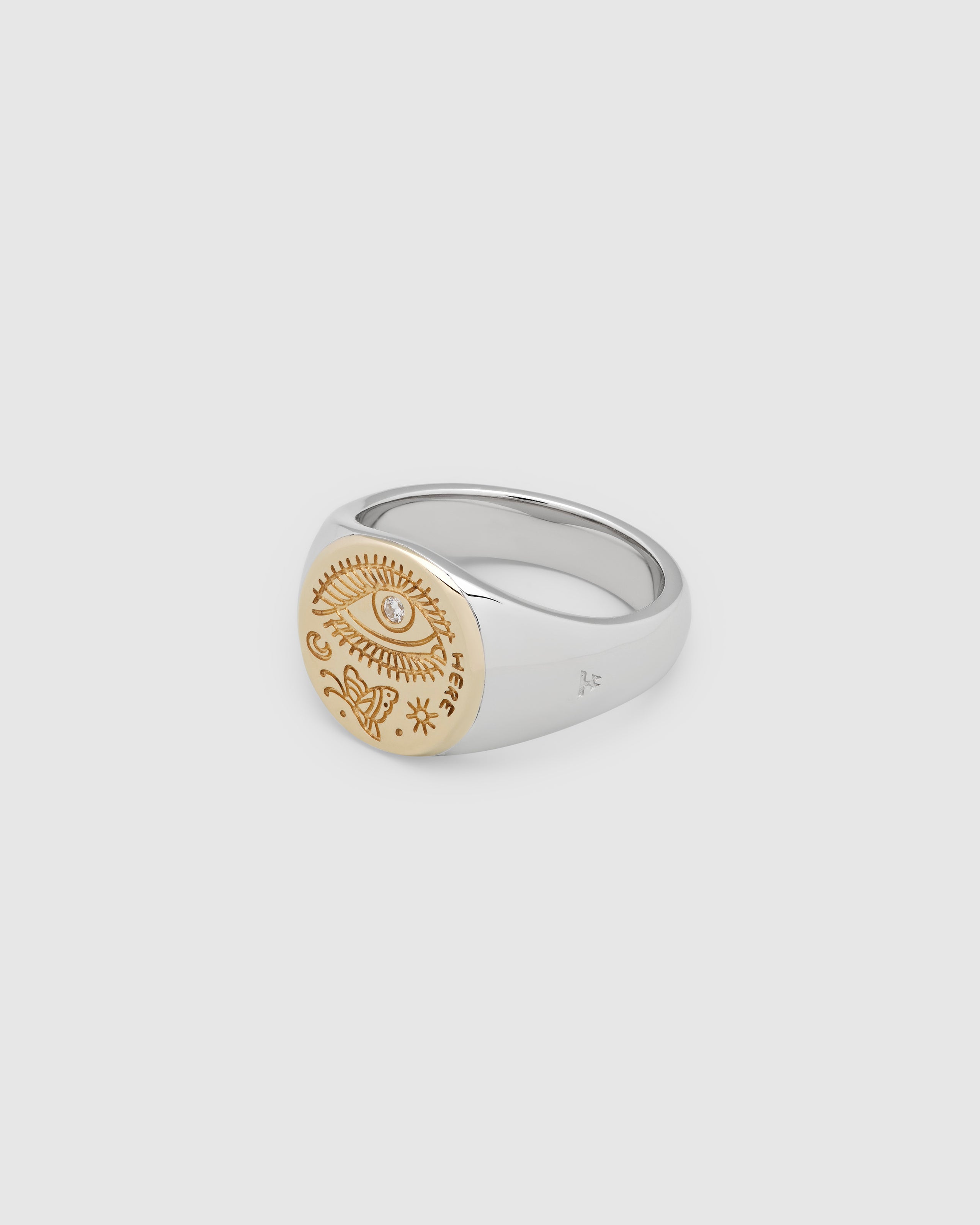 A small, round gold and 925 sterling silver signet ring for men and women, featuring an engraved butterfly motif and a hand-set, lab-grown diamond on the surface.