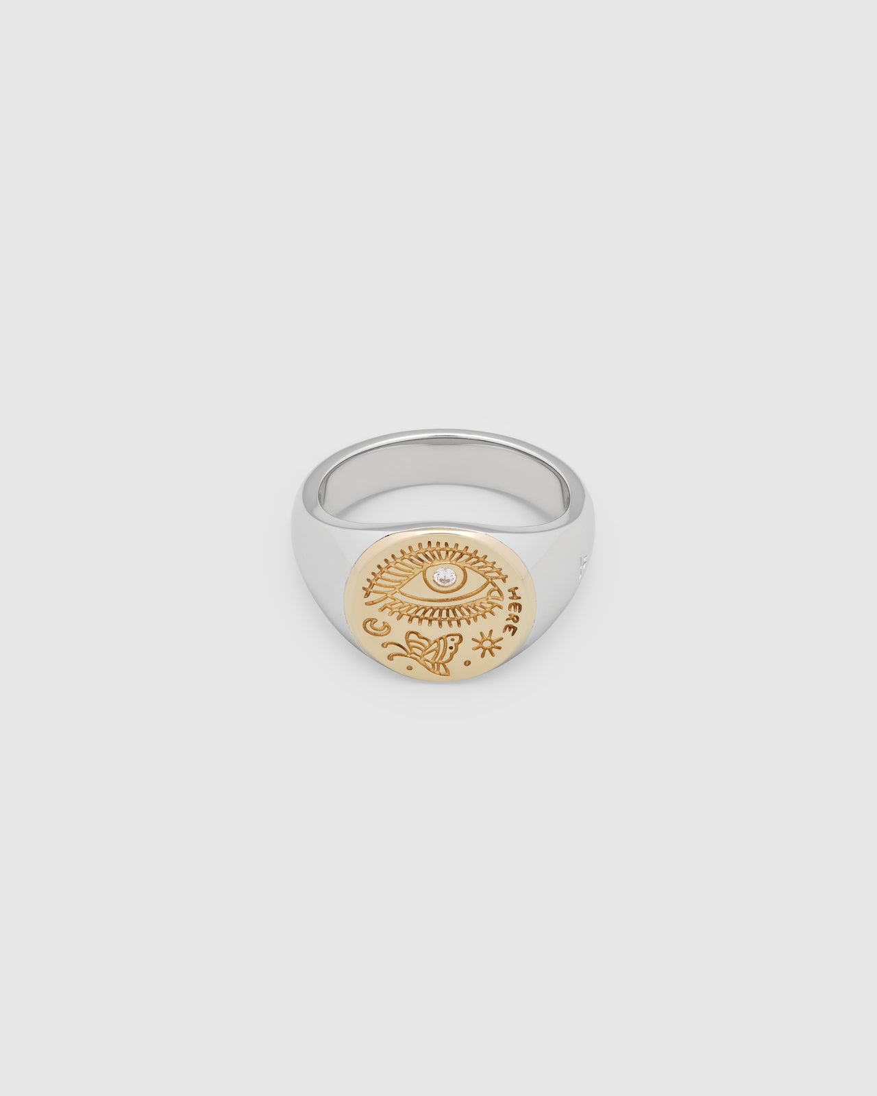 A small, round gold and 925 sterling silver signet ring for men and women, featuring an engraved butterfly motif and a hand-set, lab-grown diamond on the surface.
